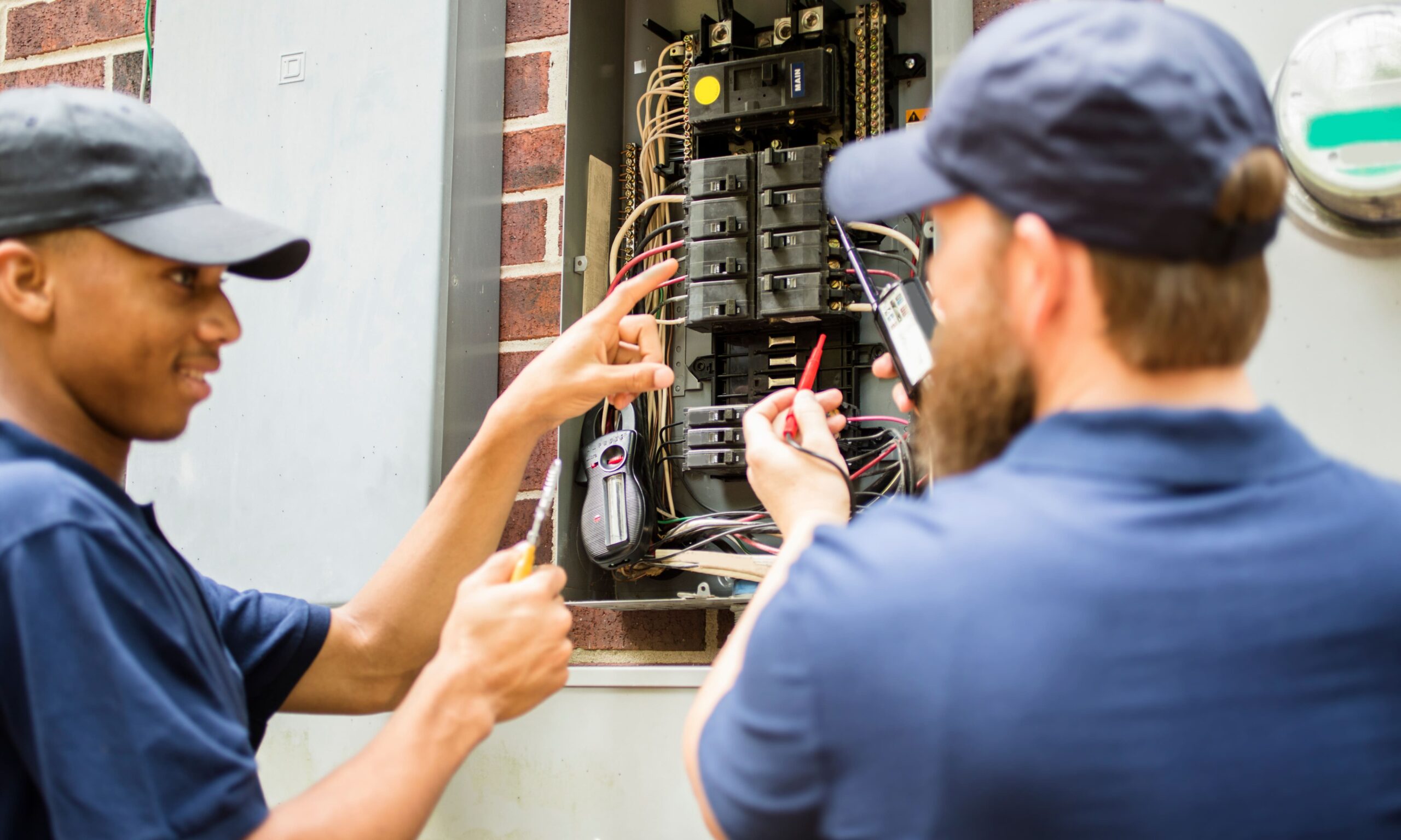 two electricians replacing circuit breakers