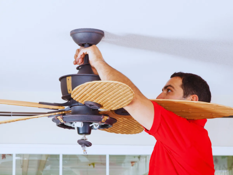 Close up of ceiling fan installation being performed professional electrician