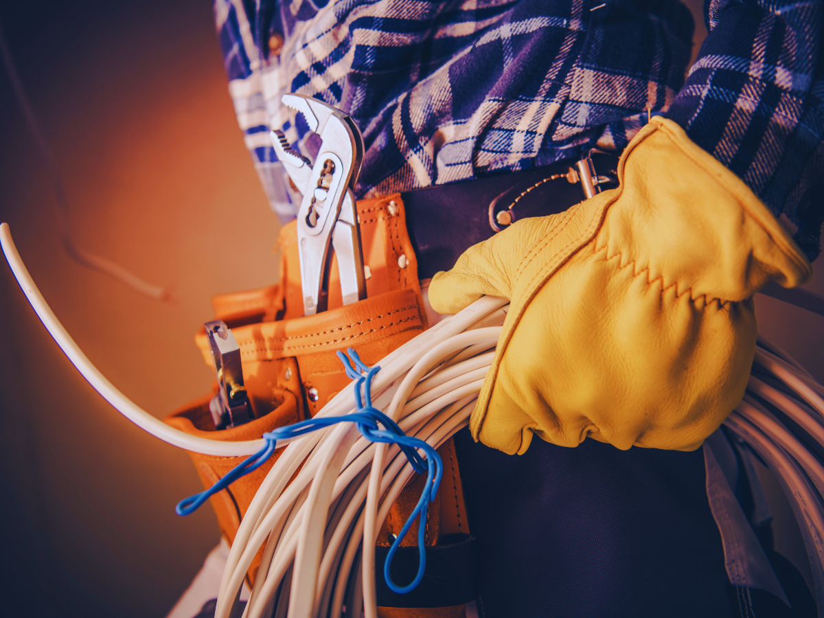 electrician wearing tool belt carrying wiring