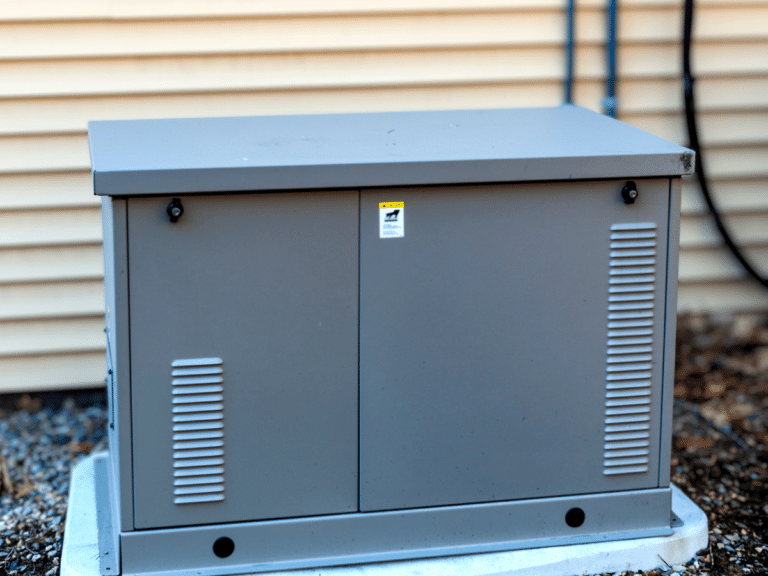 grey whole home generator outside yellow home