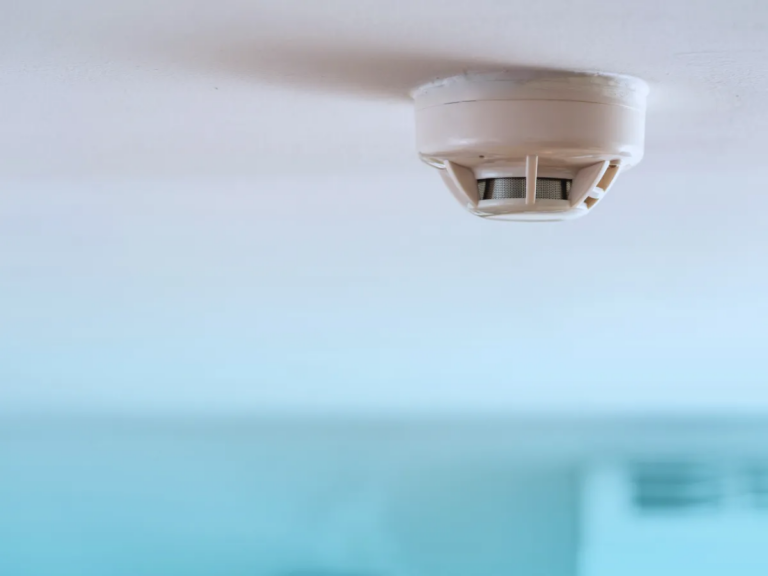 smoke rising as smoke detector on ceiling goes off