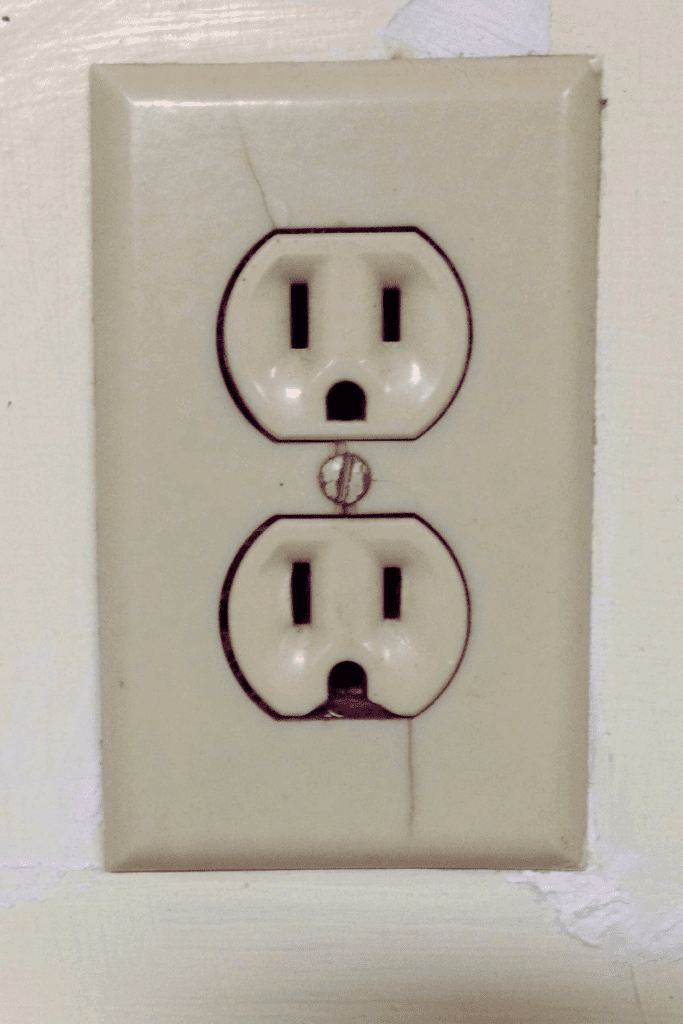 cracked and broken electrical outlet that has gone bad
